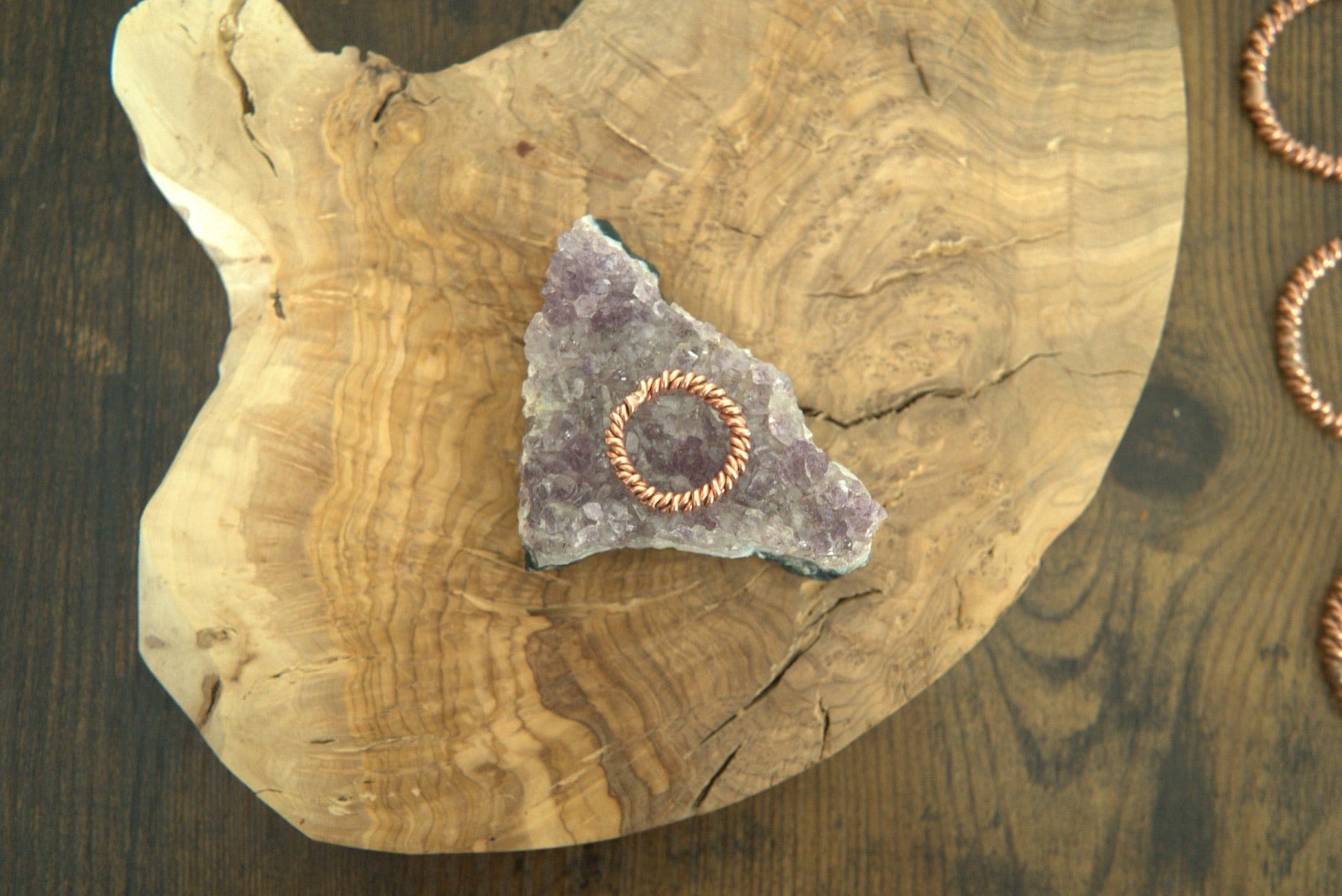 A hand-forged copper tensor ring resting on amethyst