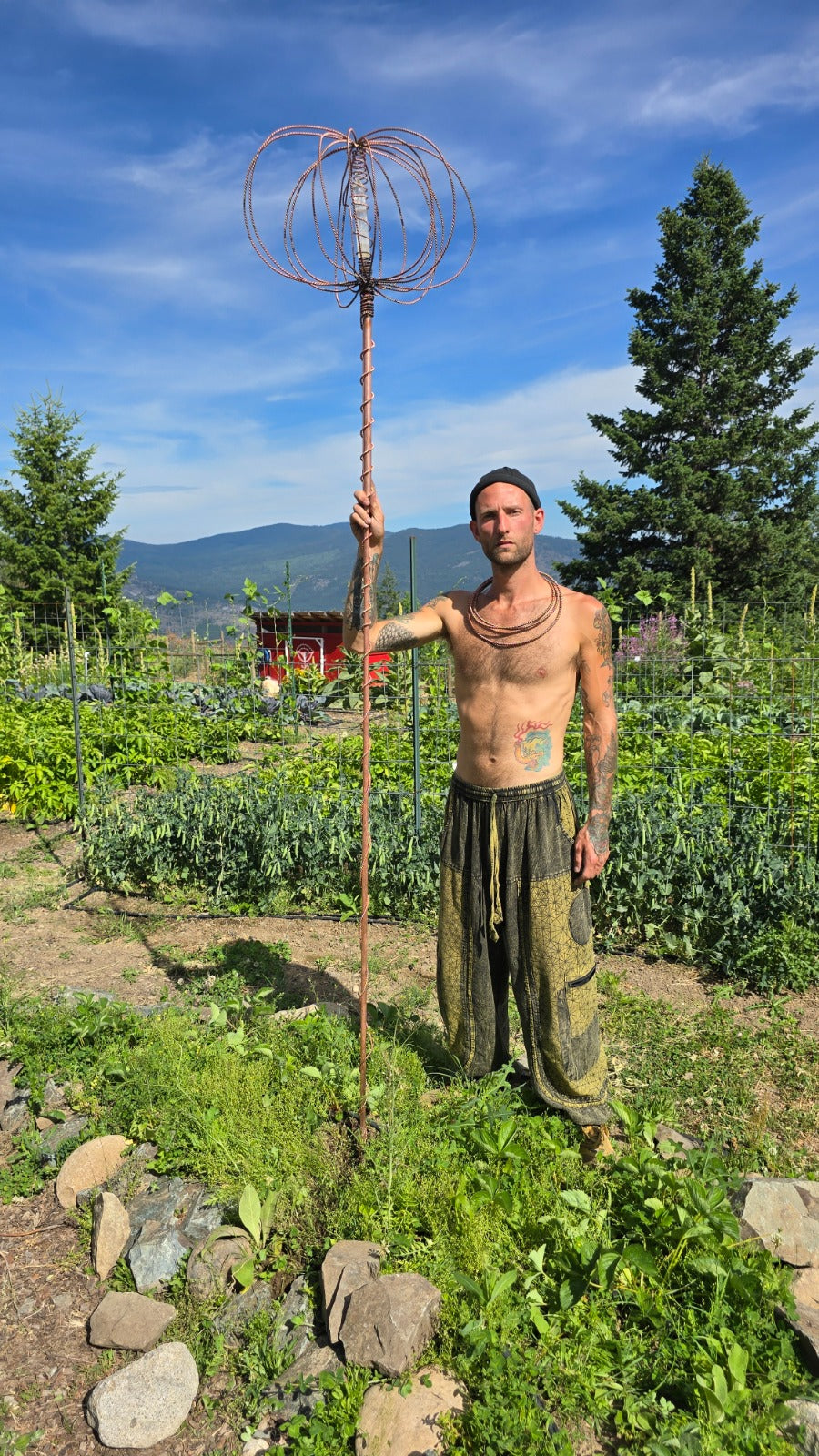The Electroculture Harmonizer Antenna standing on the land, a toroidal field rippling across the soil